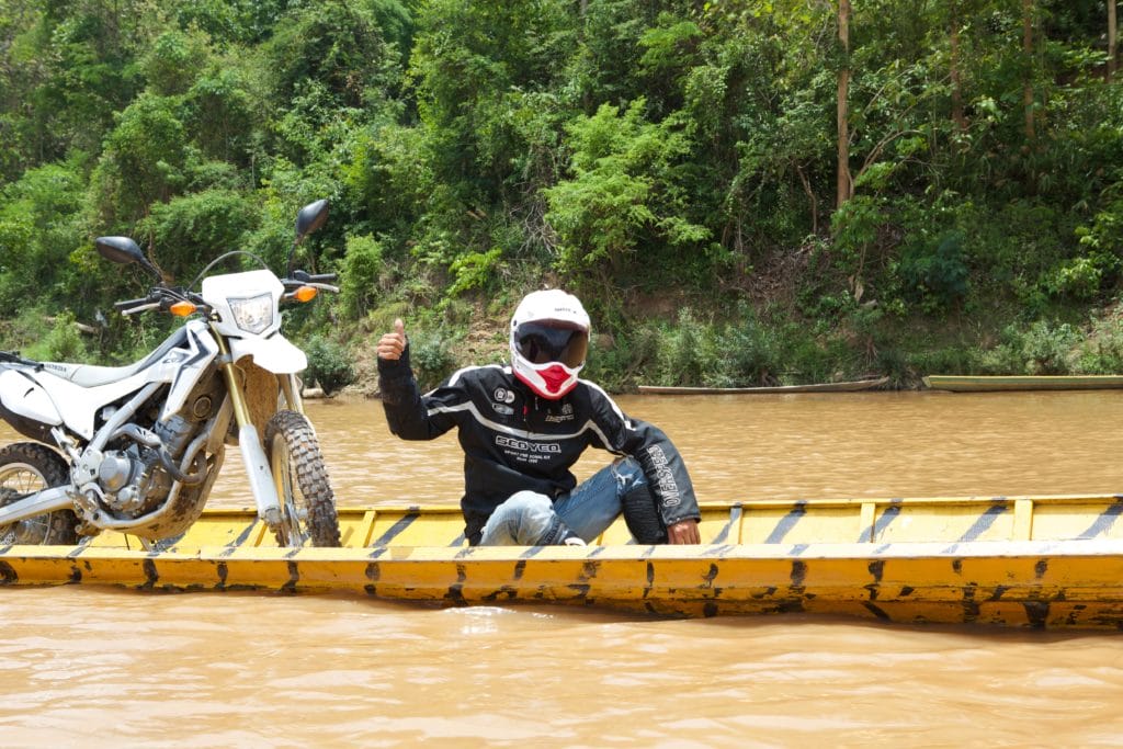 Copy of laos khmou village homestay motorbike rider in boat tiger trail photo by cyril eberle CEB 9994 1024x683 - The Best Time to Take an Off-road Motorcycle Tour in Northern Laos