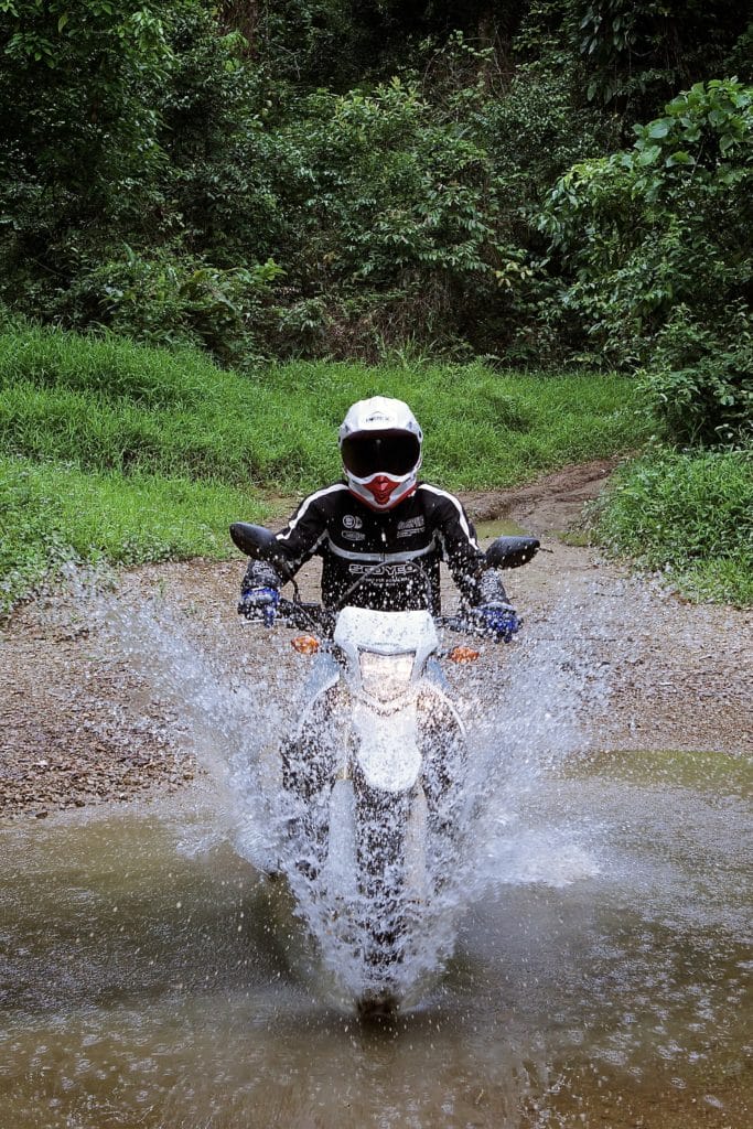 Copy of laos khmou village homestay motorbike rider in water tiger trail photo by cyril eberle CEB 9944 683x1024 - Laos motorbike Buffalo Tour