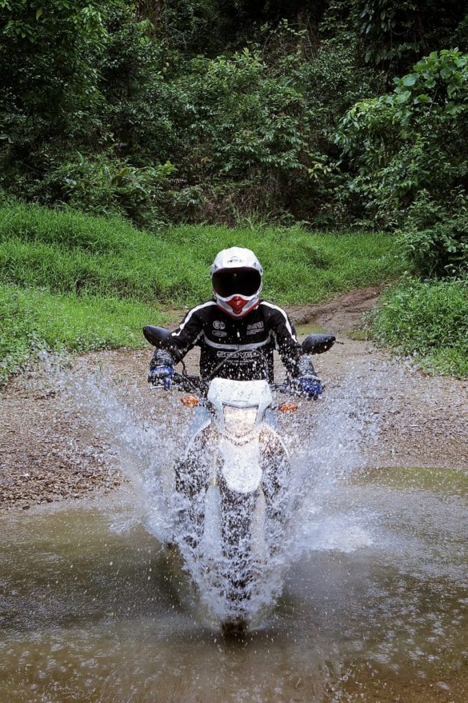 Copy of laos khmou village homestay motorbike rider in water tiger trail photo by cyril eberle CEB 9944 - Laos motorbike Buffalo Tour