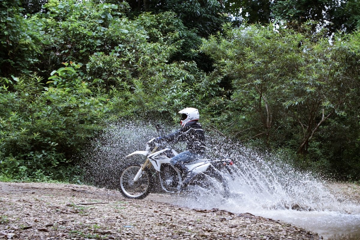 Copy of laos khmou village homestay motorbike rider in water tiger trail photo by cyril eberle CEB 9959 - Why a Cambodia Off-Road Motorbike Tour is the Ultimate Adventure